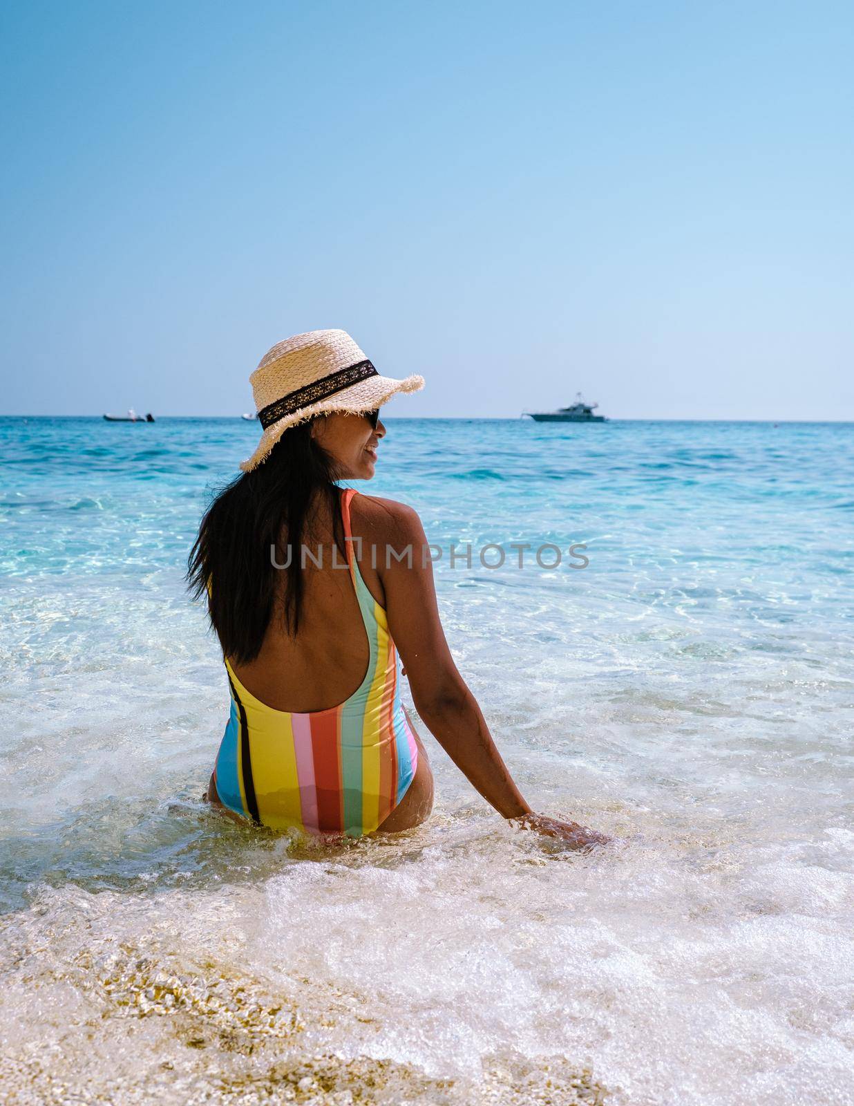 Golfo di Orosei Sardina, Asian women on the beach Sardinia Italy, young girl on vacation Sardinia Italy, woman playing in the ocean with crystal clear blue water, by fokkebok