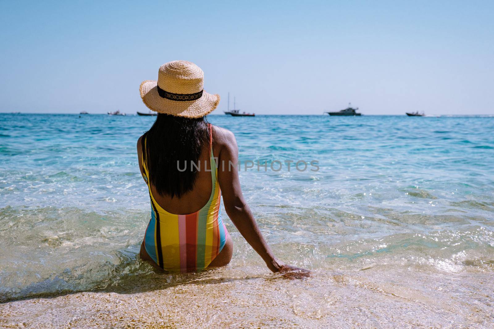 Golfo di Orosei Sardina, Asian women on the beach Sardinia Italy, young girl on vacation Sardinia Italy, woman playing in the ocean with crystal clear blue water, by fokkebok