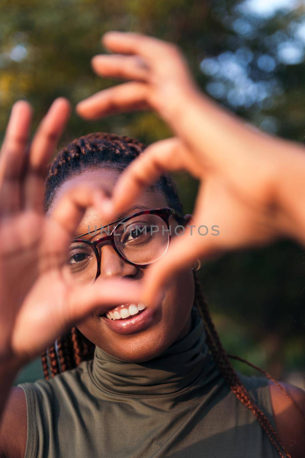 young black woman making the shape of a heart with her hands, concept of love and youth, copy space for text
