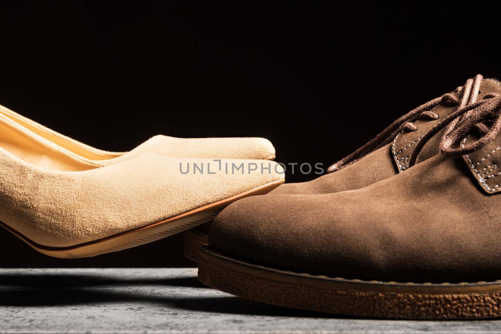 Women's shoes stand on top of men's shoes. The concept of feminization in social and family life.