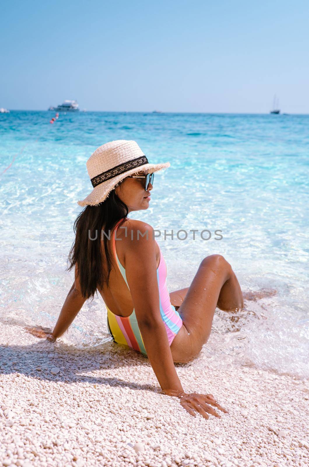 Golfo di Orosei Sardina, Asian women on the beach Sardinia Italy, a young girl on vacation Sardinia Italy, woman playing in the ocean with crystal clear blue water,