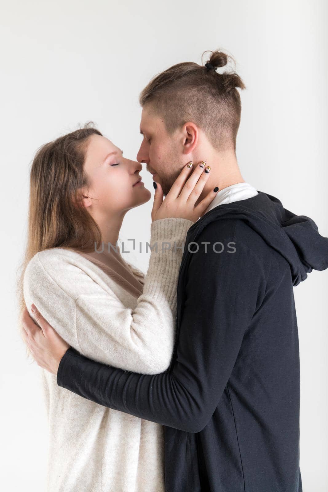 Young caucasian couple of lovers close-up vertical portrait on white background.
