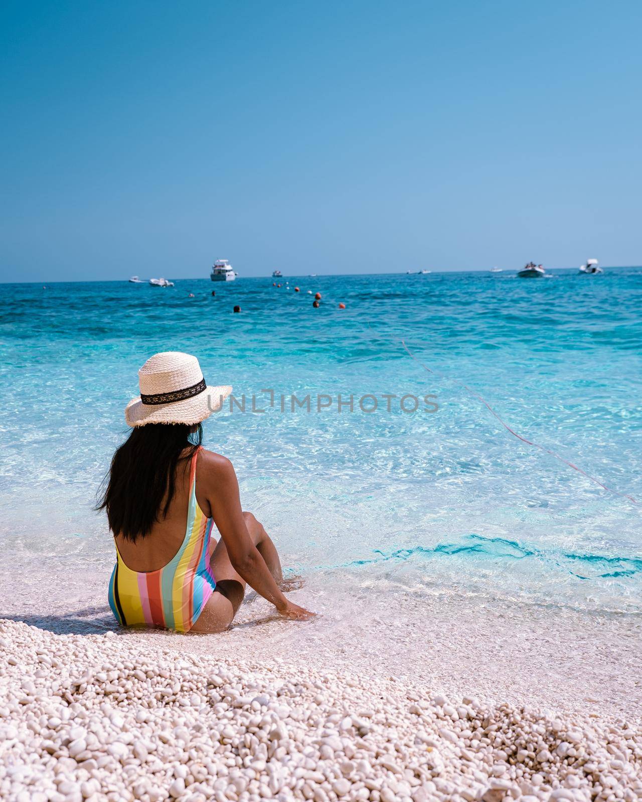 Golfo di Orosei Sardina, Asian women on the beach Sardinia Italy, a young girl on vacation Sardinia Italy, woman playing in the ocean with crystal clear blue water,