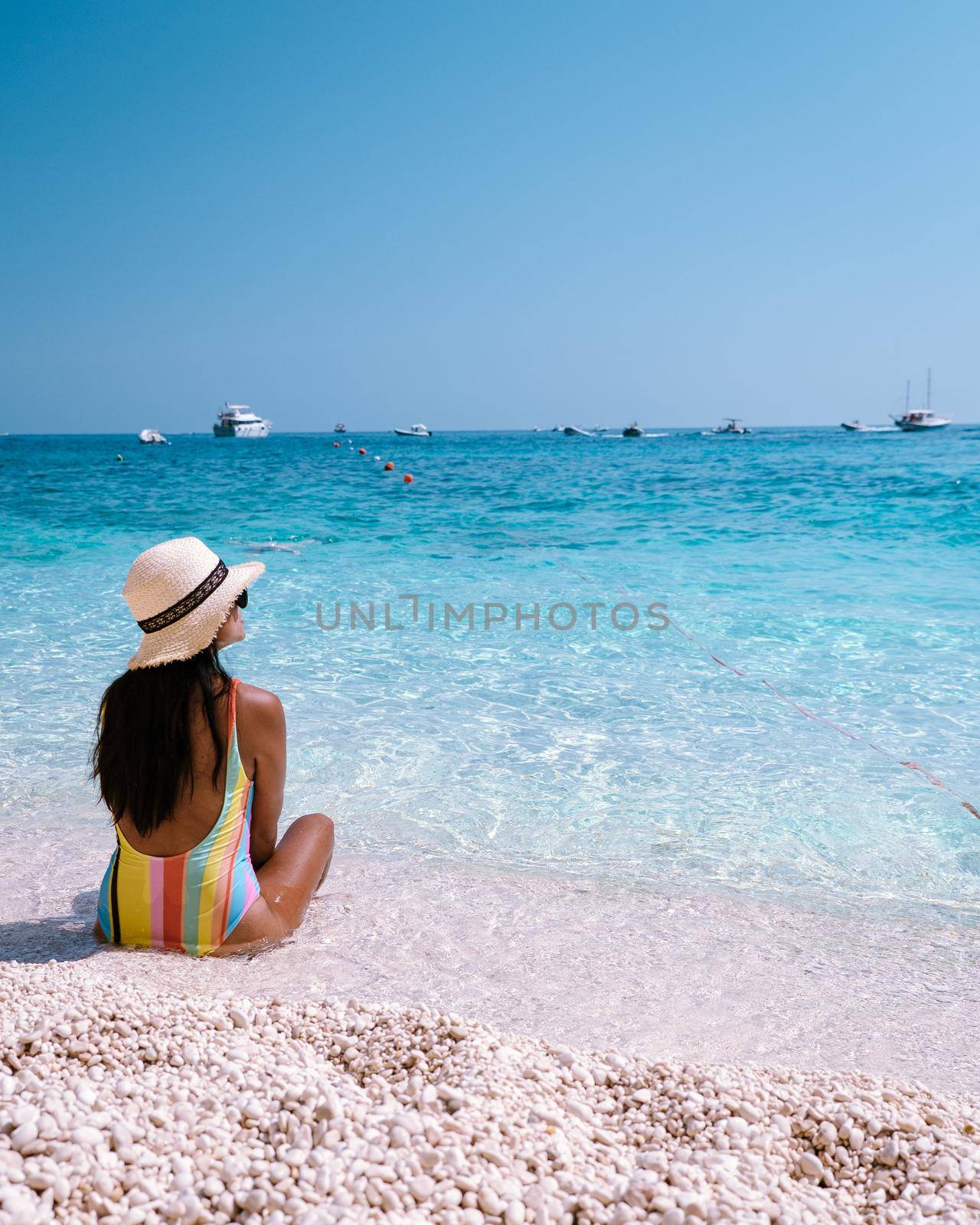 Golfo di Orosei Sardina, Asian women on the beach Sardinia Italy, a young girl on vacation Sardinia Italy, woman playing in the ocean with crystal clear blue water,