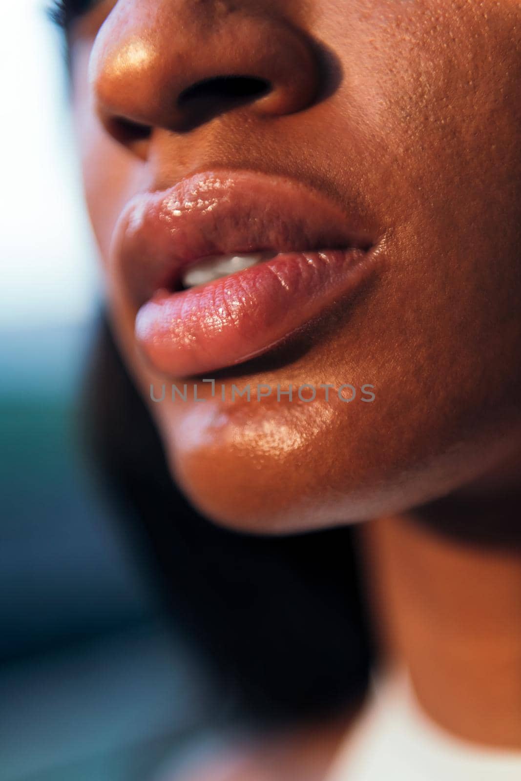 close-up detail of the full-lipped mouth of a young african woman, vertical photo, copy space for text