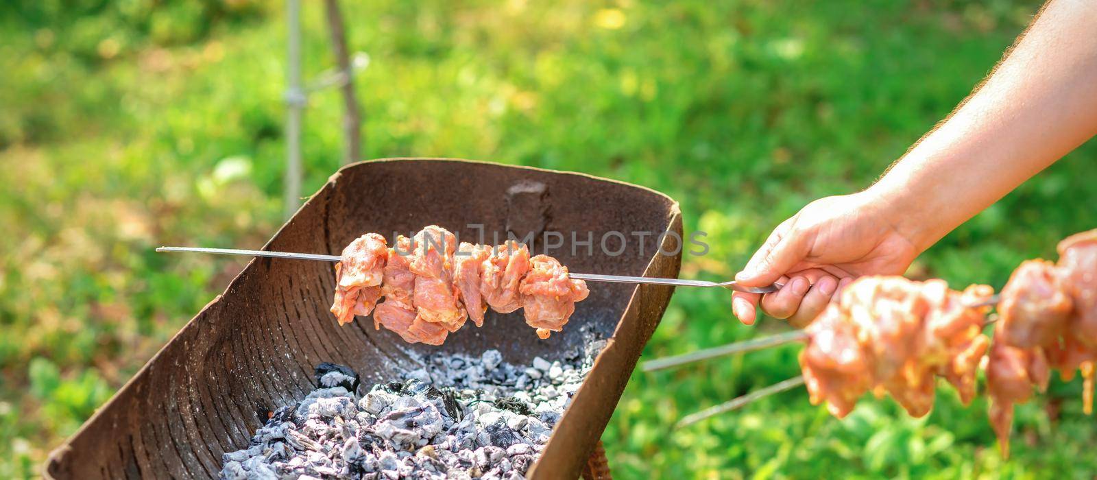 Hands of man prepares barbecue meat by okskukuruza