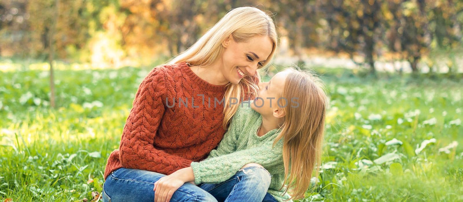 Happy smiling young caucasian mother and little daughter hugging each other outdoors. Happy family outdoor.