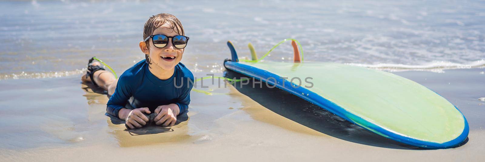 Young surfer, happy young boy at the beach with surfboard. BANNER, LONG FORMAT