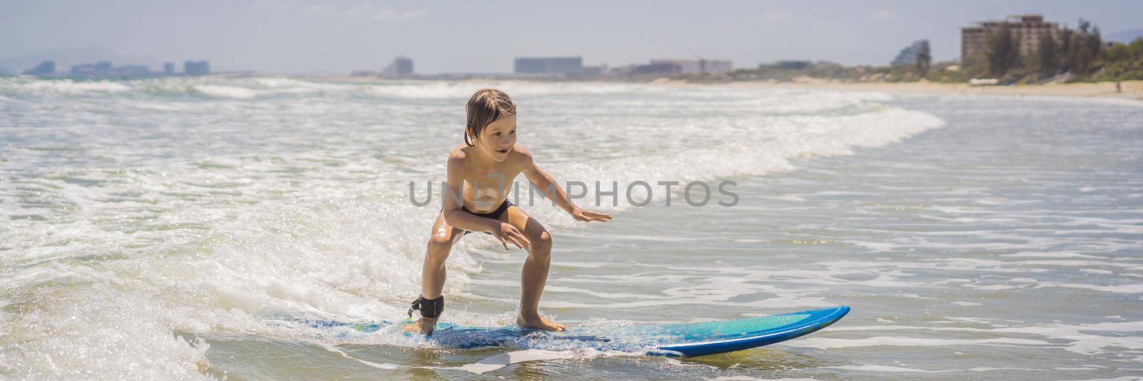 Healthy young boy learning to surf in the sea or ocean. BANNER, LONG FORMAT