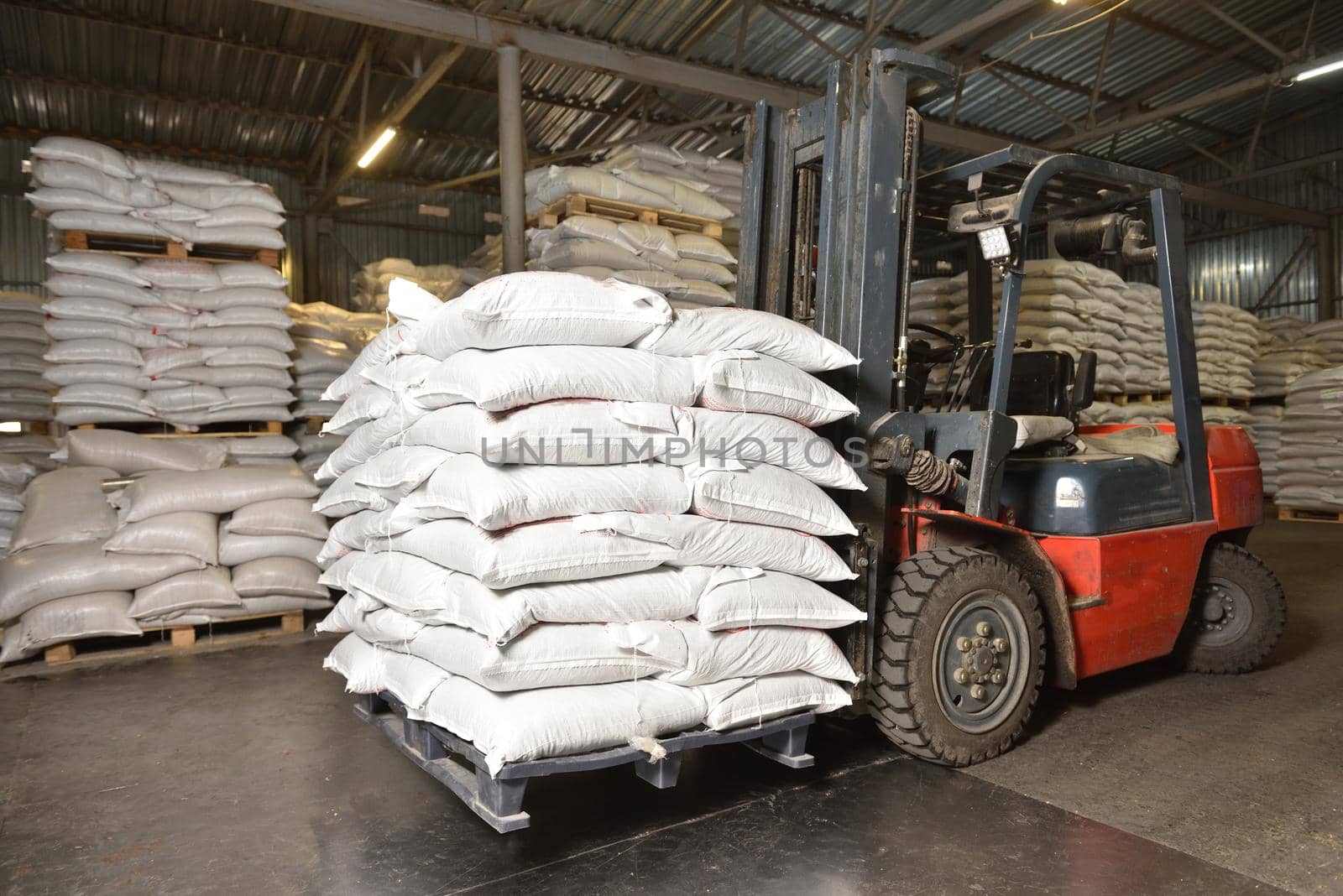 Forklift in a warehouse with wheat in sacks.