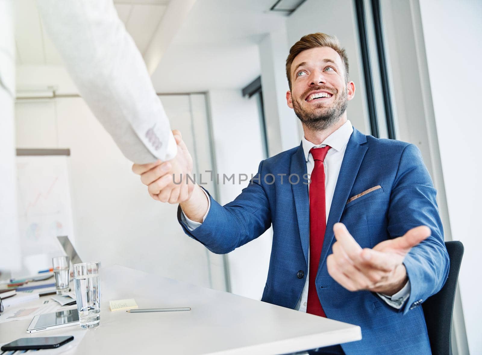 portrait of a young business man offering hand shaking hands introducing in the office