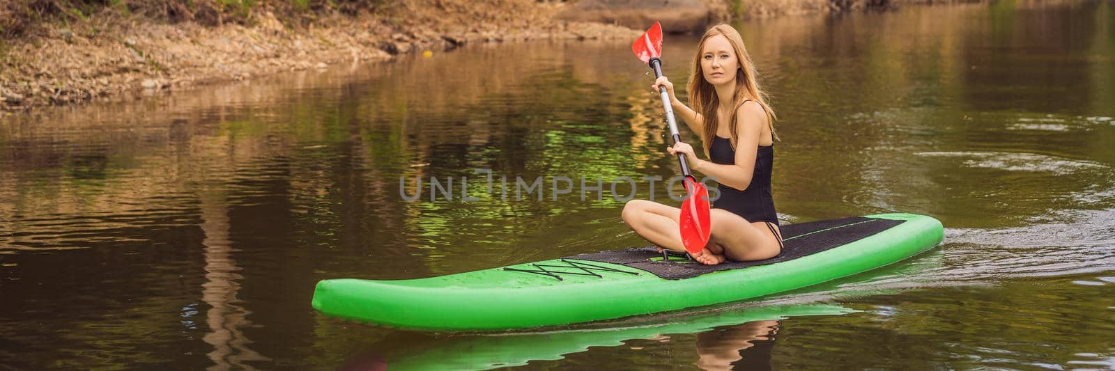 SUP Stand up paddle board woman paddle boarding on lake standing happy on paddleboard on blue water. Action Shot of Young Woman on Paddle Board BANNER, LONG FORMAT by galitskaya