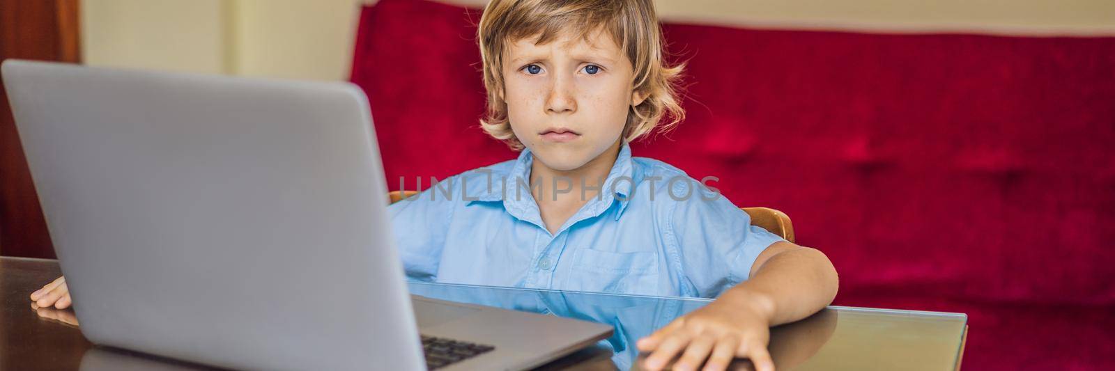 Boy studying online at home using laptop. Studying during quarantine. Global pandemic covid19 virus BANNER, LONG FORMAT by galitskaya