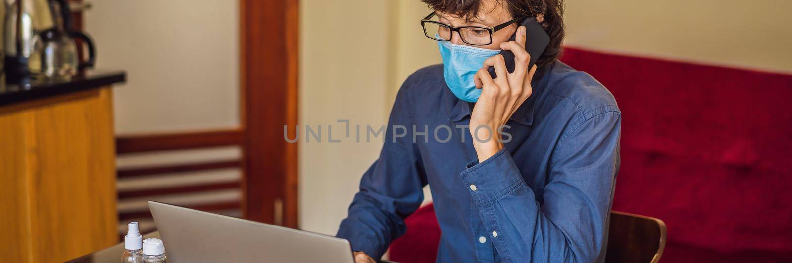 Coronavirus. Man working from home wearing protective mask. quarantine for coronavirus wearing protective mask. Working from home BANNER, LONG FORMAT by galitskaya