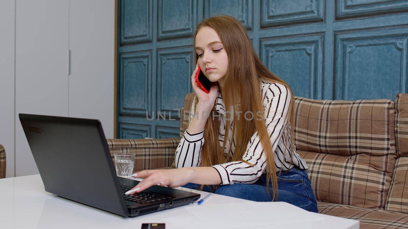 Smiling young business woman professional consultant talking, on mobile phone, using laptop sit at home office in living room, customer make call confirming online website shopping order delivery