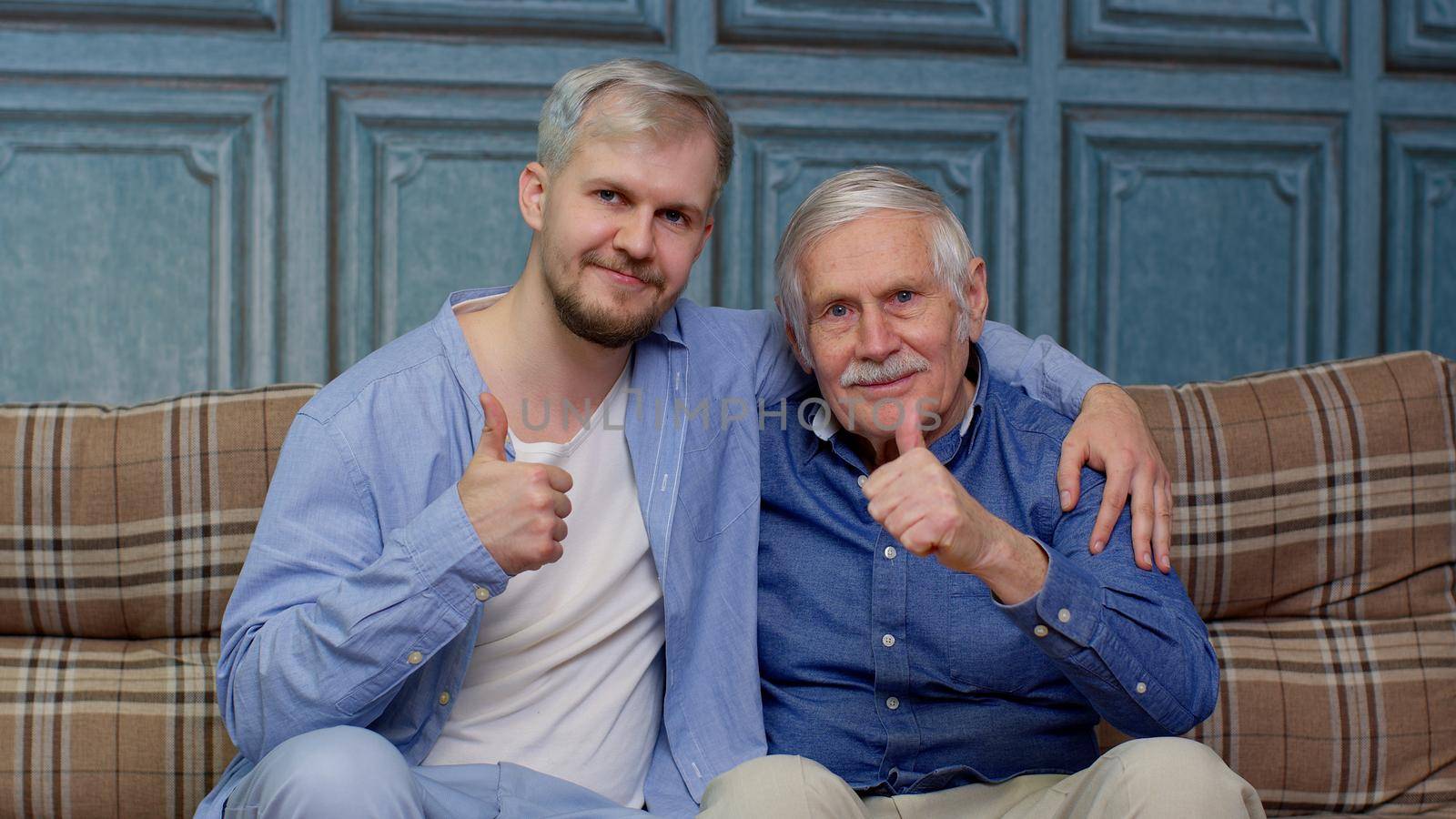 Cheerful excited young man with gray-haired old dad or grandfather. Joyful bonding loving different male generations family of senior father and handsome adult son or grandson showing thumb up gesture