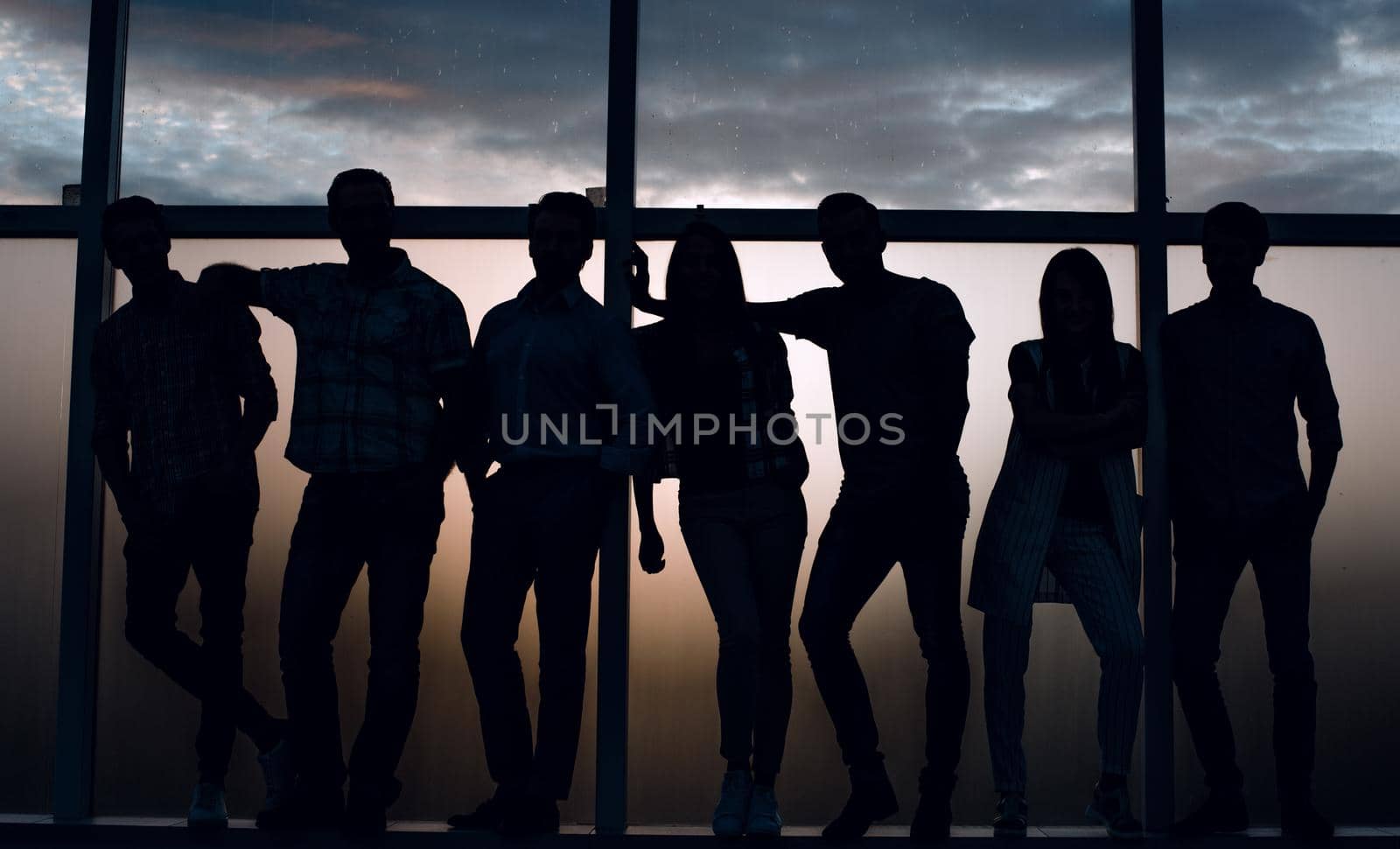 group of modern youth standing near a large window.photo with copy space