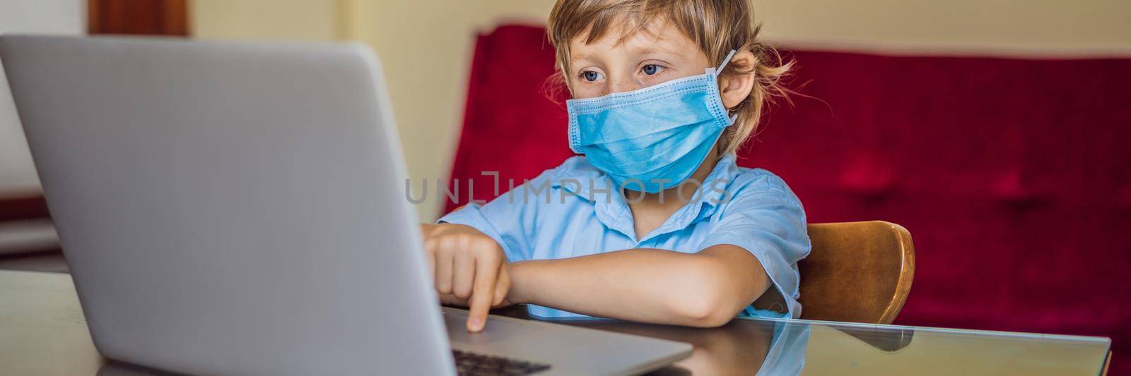 Boy studying online at home using laptop in medical masks to protect against coronovirus. Studying during quarantine. Global pandemic covid19 virus. BANNER, LONG FORMAT