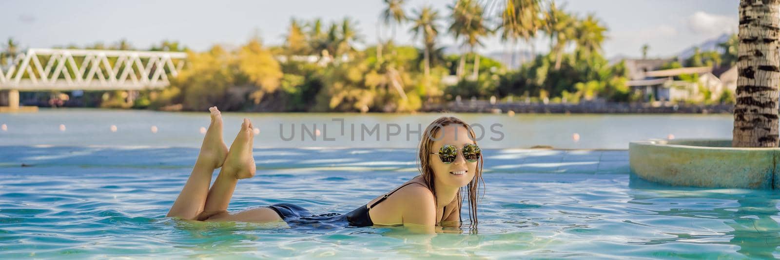 Luxury resort swimming pool. Beautiful woman tourist relaxing in holiday retreat on summer travel vacation. Bikini girl in sunbathing swimsuit enjoying ocean background BANNER, LONG FORMAT by galitskaya