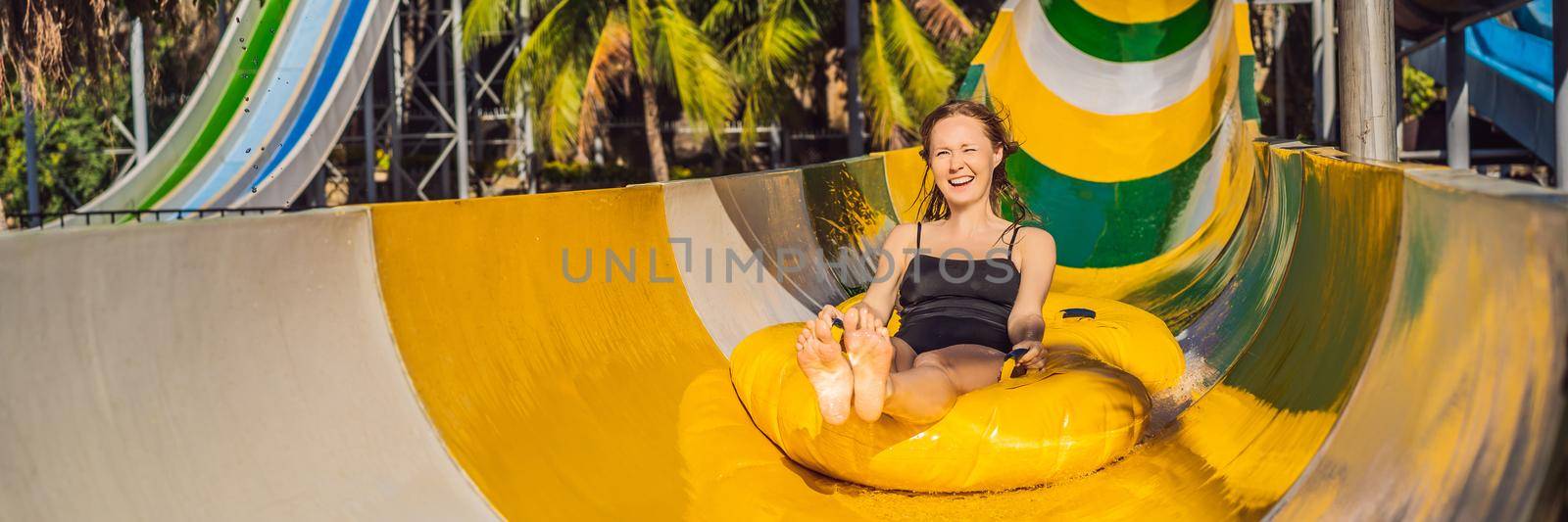 Happy woman going down a water slide. BANNER, LONG FORMAT
