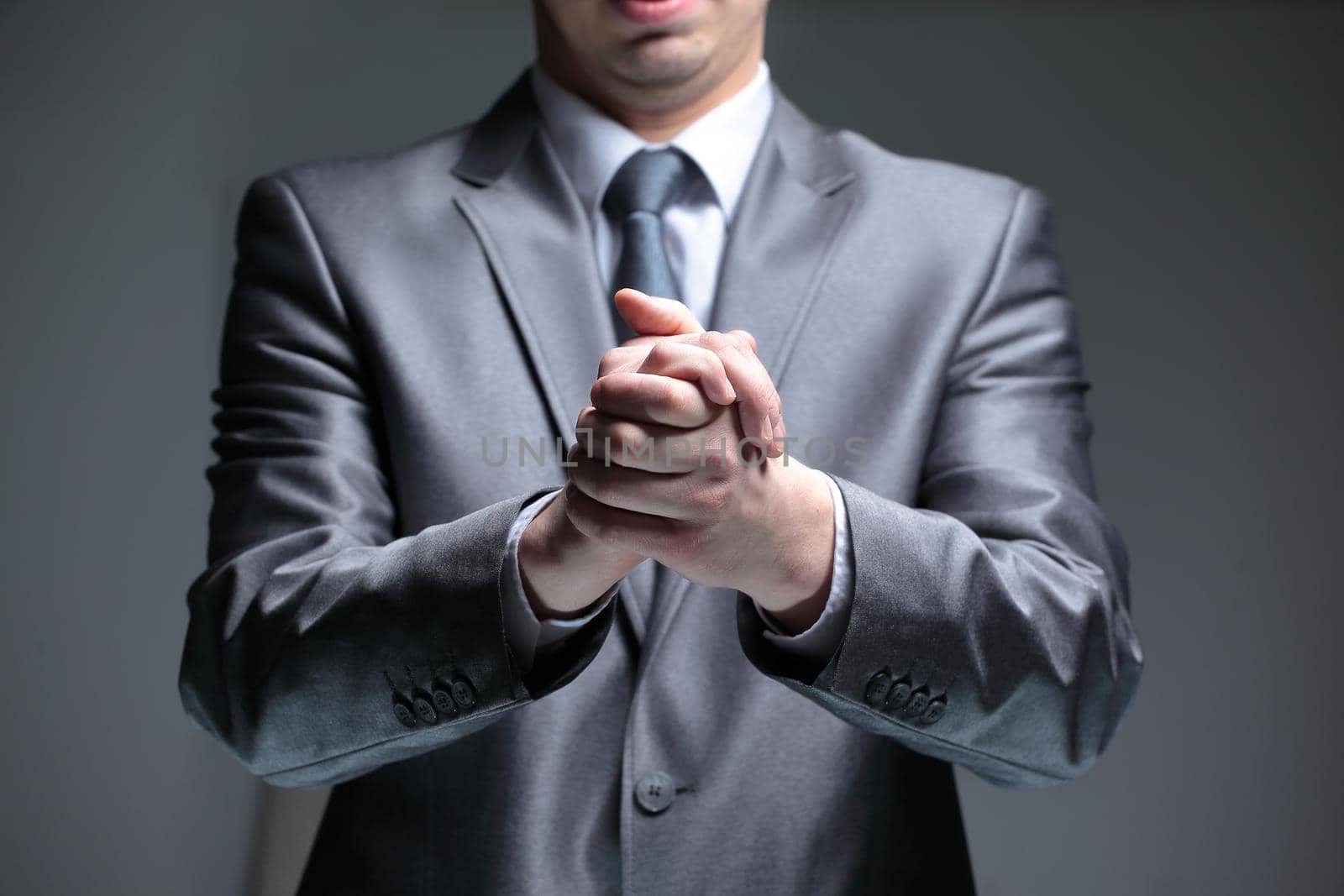 close up.businessman folded his hands .isolated on black background.