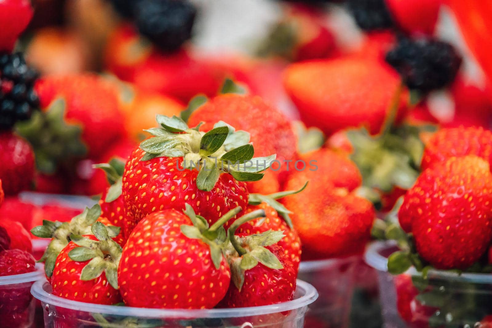 Selective focus. fresh strawberries, raspberries and blackberries in a glass. Summer Beach Food.