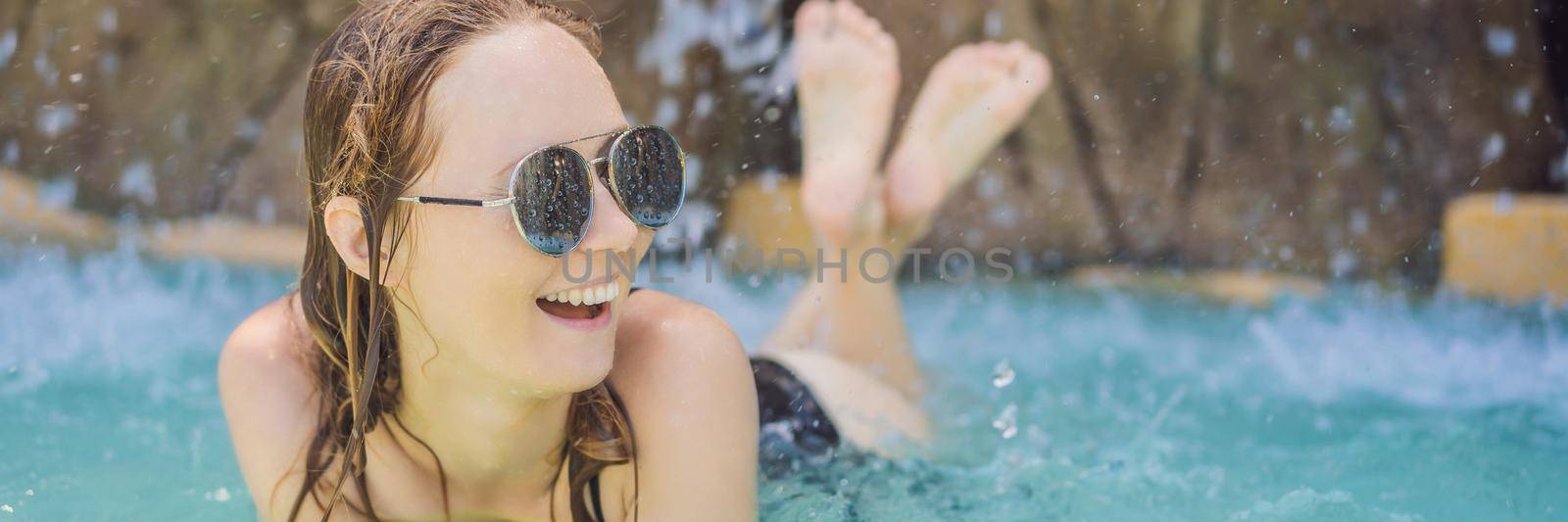 Young joyful woman under the water stream, pool, day spa, hot springs. BANNER, LONG FORMAT
