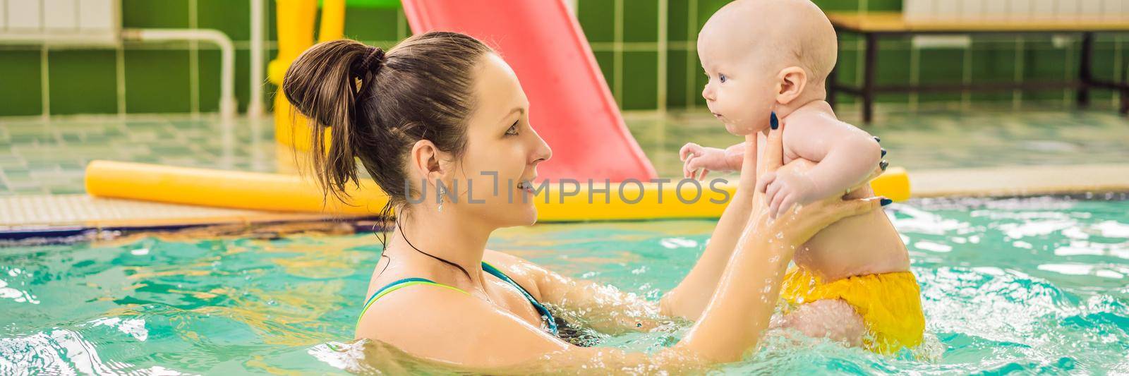 Beautiful mother teaching cute baby girl how to swim in a swimming pool. Child having fun in water with mom BANNER, LONG FORMAT by galitskaya