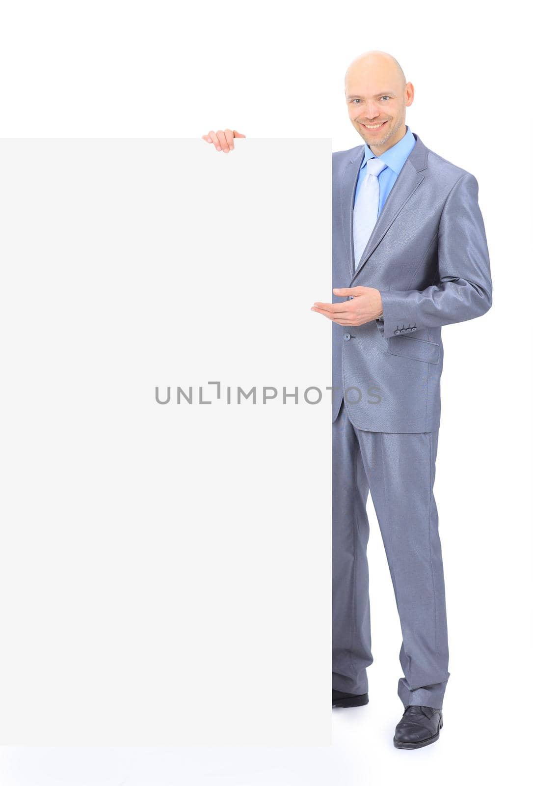 Nice businessman holds white poster. Isolated on a white background.