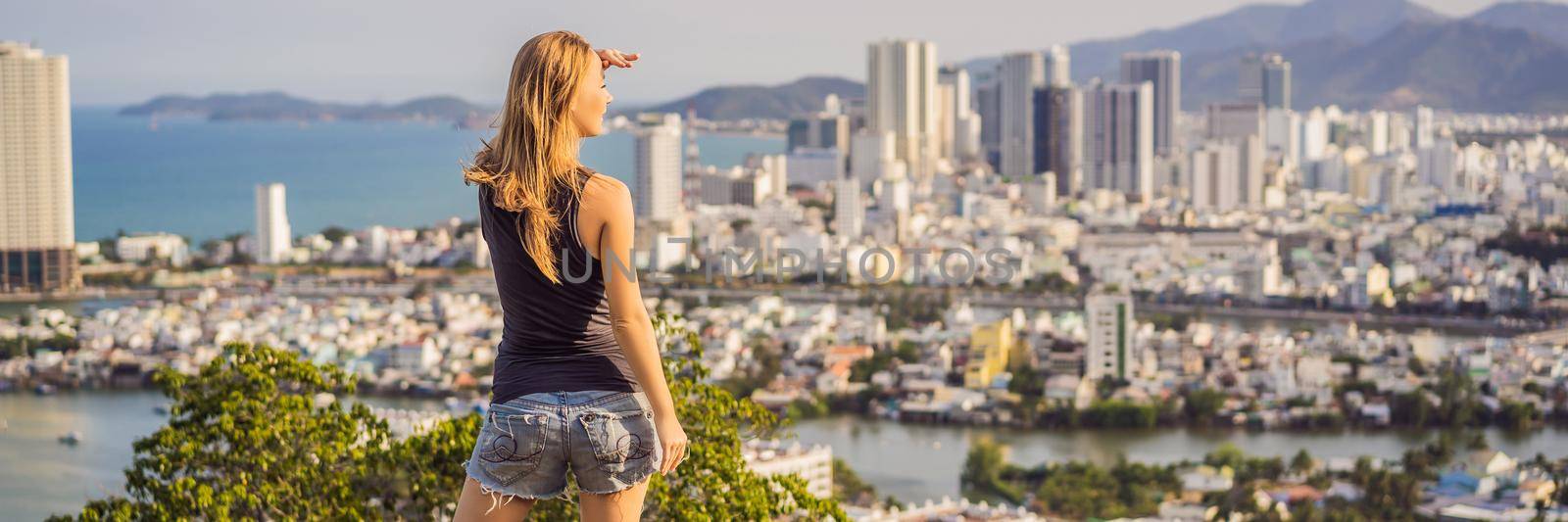 Woman tourist on the background of Nha Trang city. Travel to Vietnam Concept. BANNER, LONG FORMAT