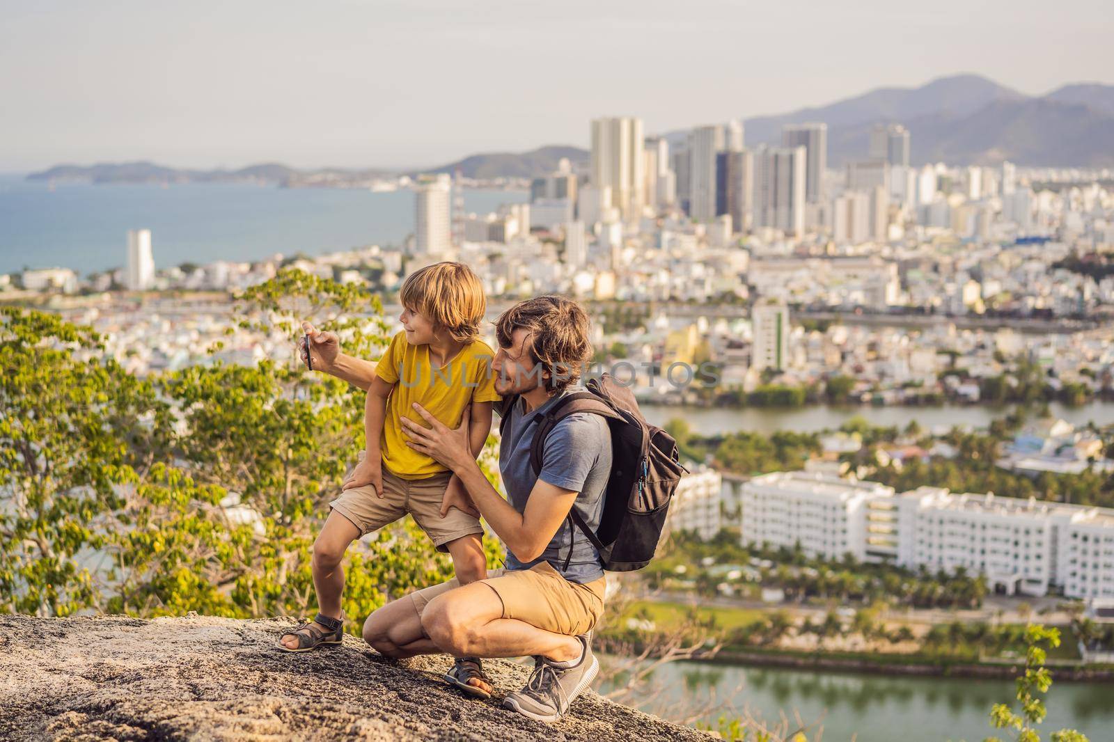 Dad and son tourists on the background of Nha Trang city. Travel to Vietnam with kids Concept.