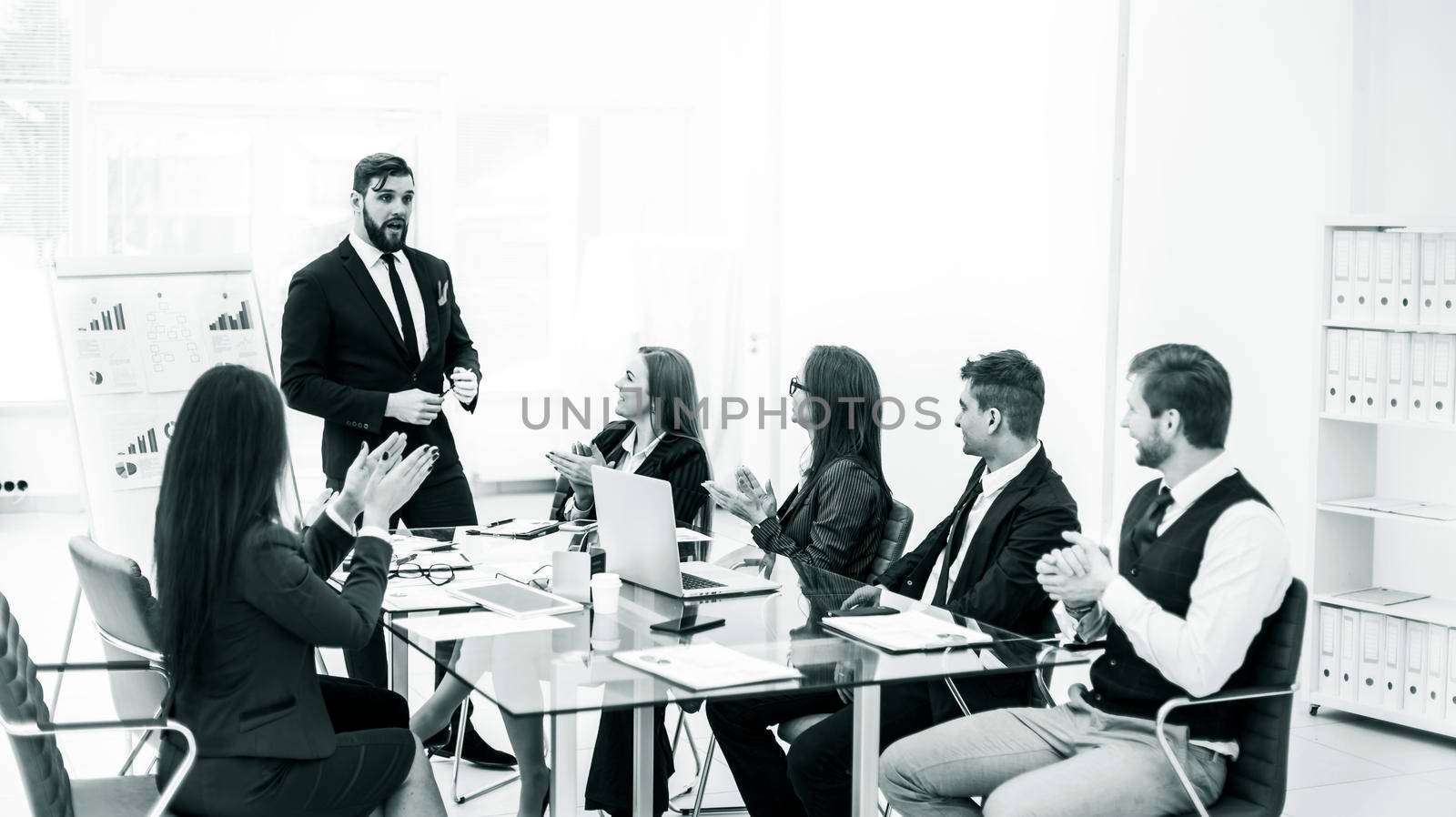 black-and-white photo:successful business team applauding the Manager Finance on the presentation of the new project in the workplace in the office