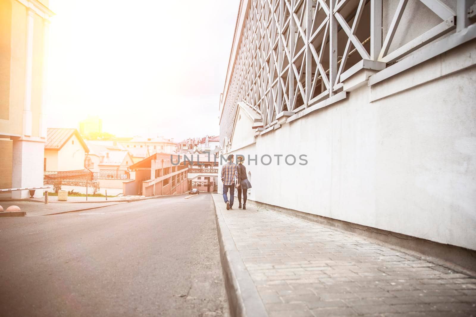 couple in love walking down the street of a modern city. by SmartPhotoLab