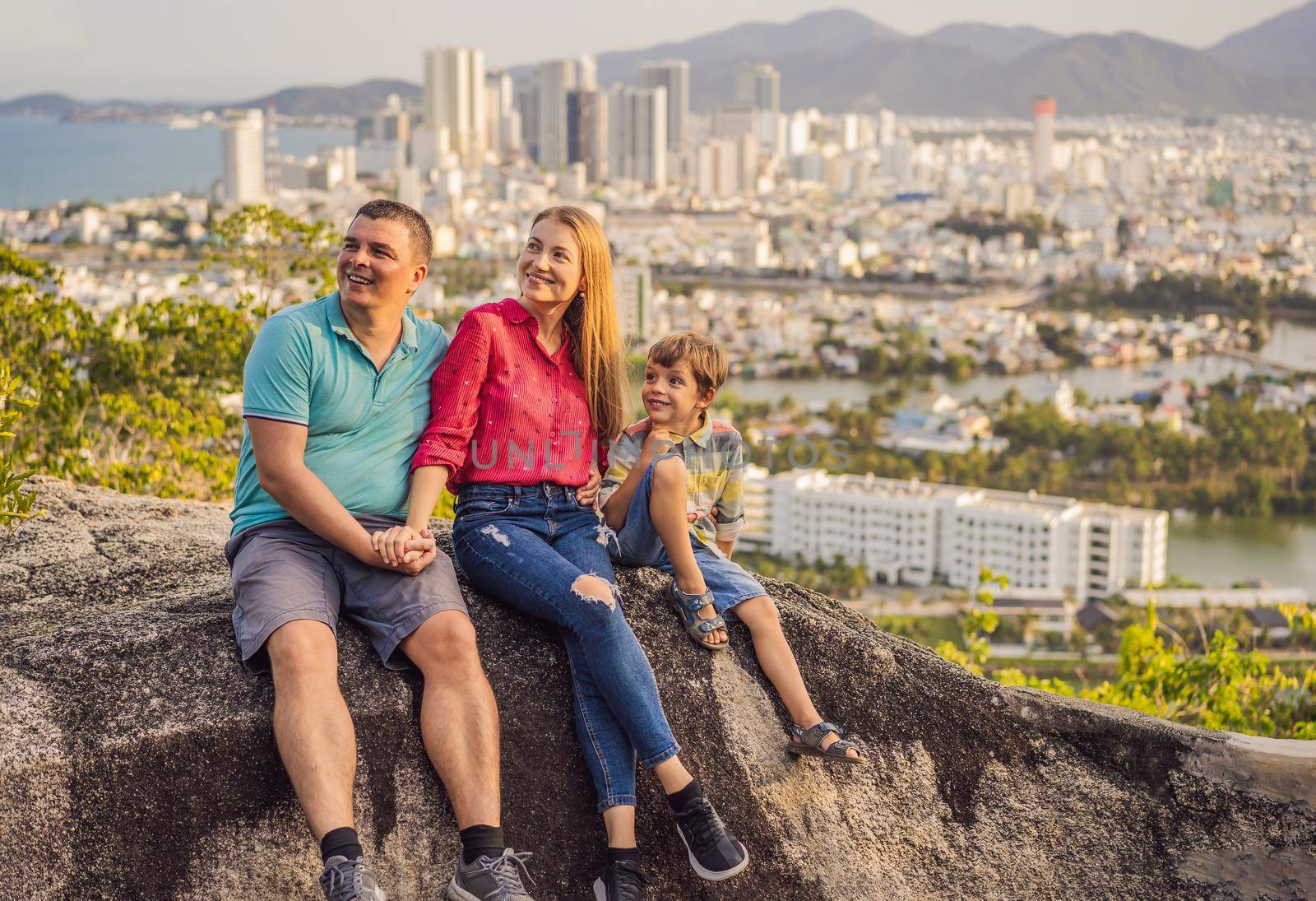 Happy family tourists on the background of Nha Trang city. Travel to Vietnam with kids Concept.