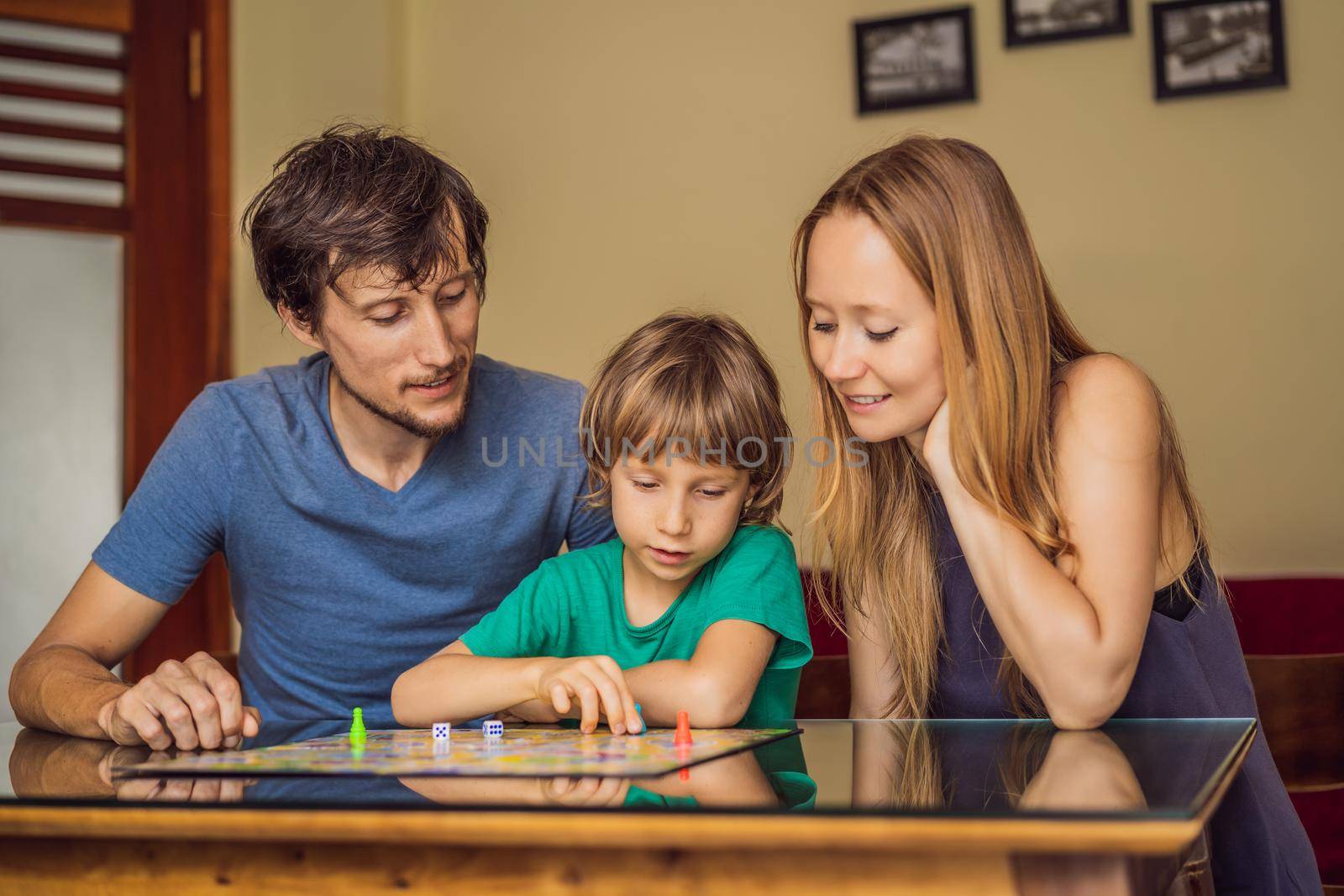 Happy Family Playing Board Game At Home.