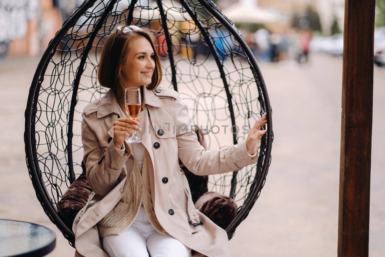 A happy stylish girl In a gray coat walks around the city.