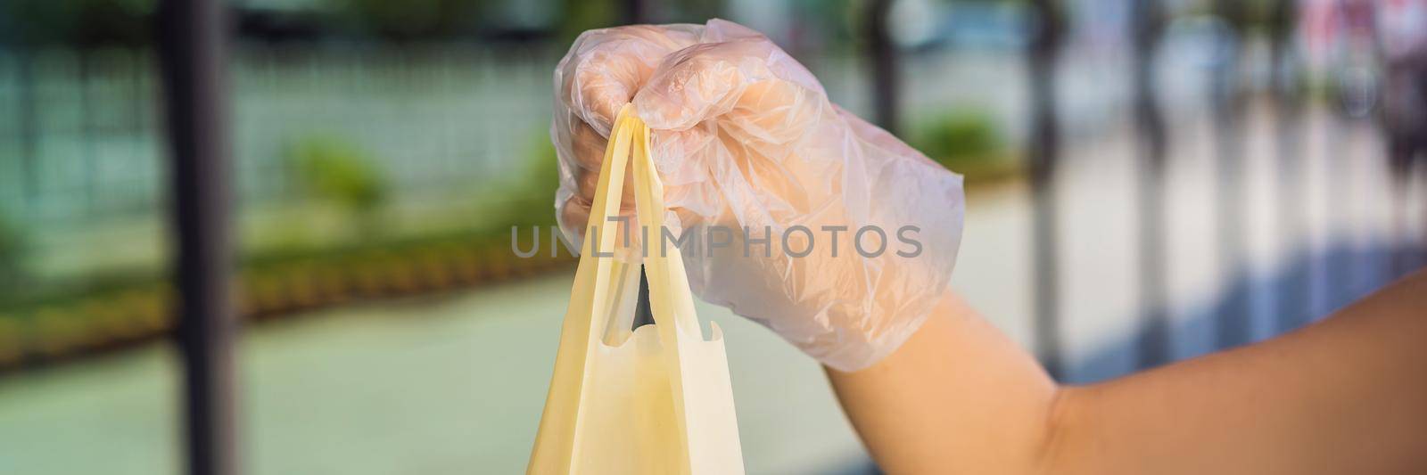 Woman hands in medical protective gloves hold package with purchases BANNER, LONG FORMAT by galitskaya