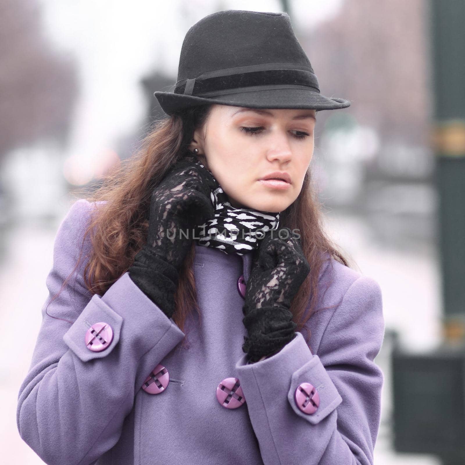 Beautiful girl in a fashionable hat in a coat