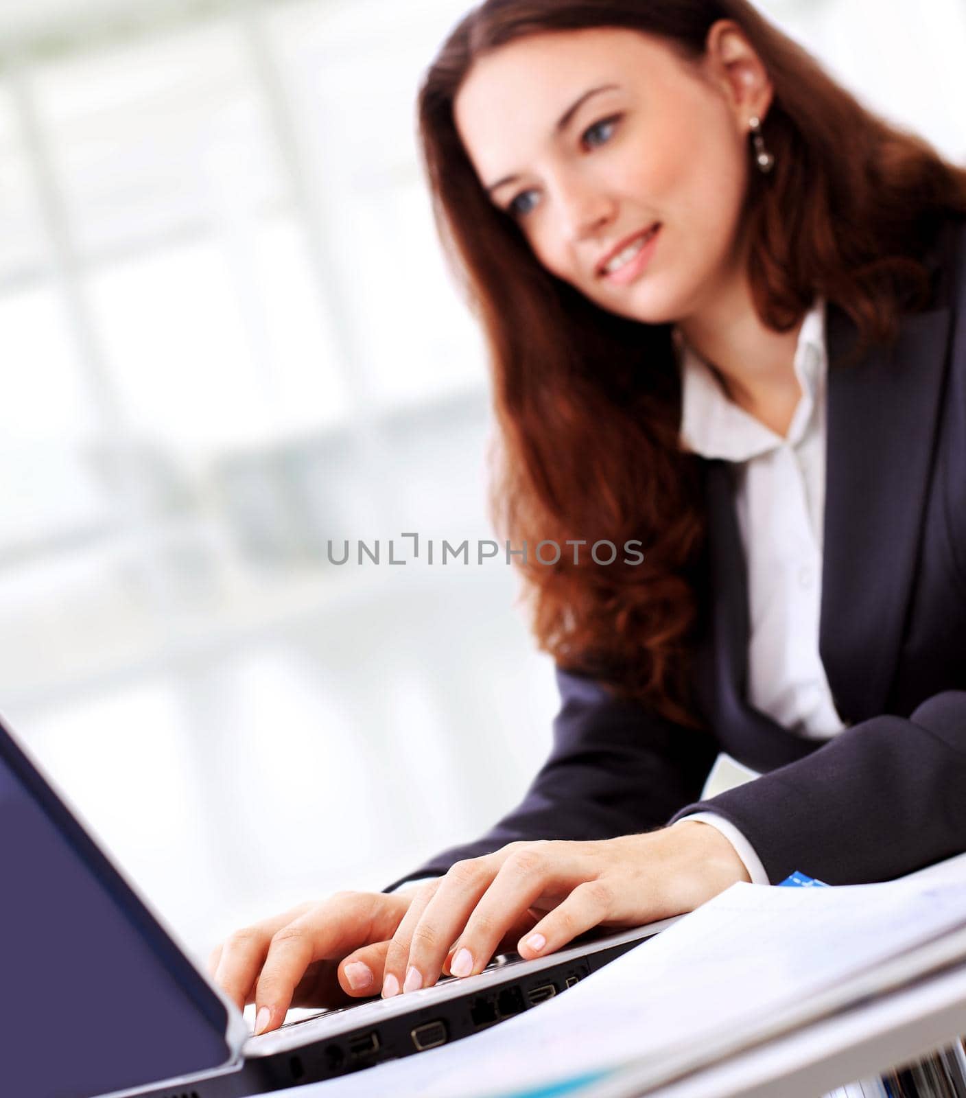 Thoughtful business woman in an office smiling.