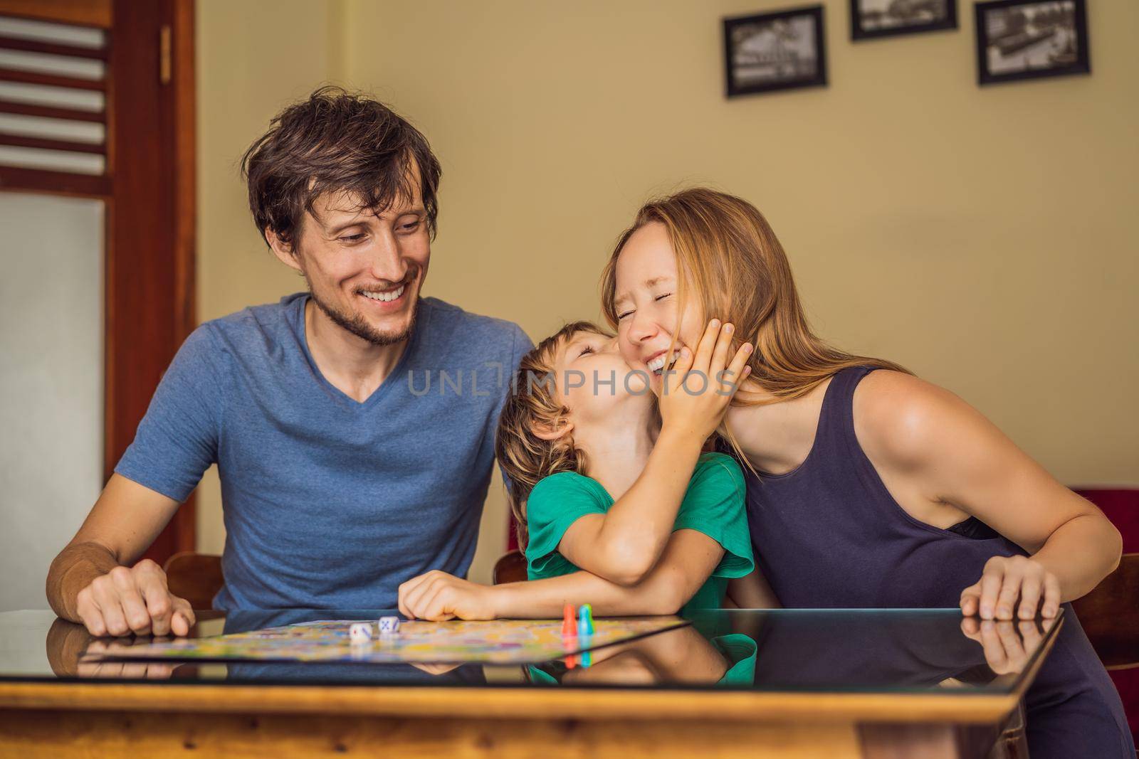 Happy Family Playing Board Game At Home by galitskaya
