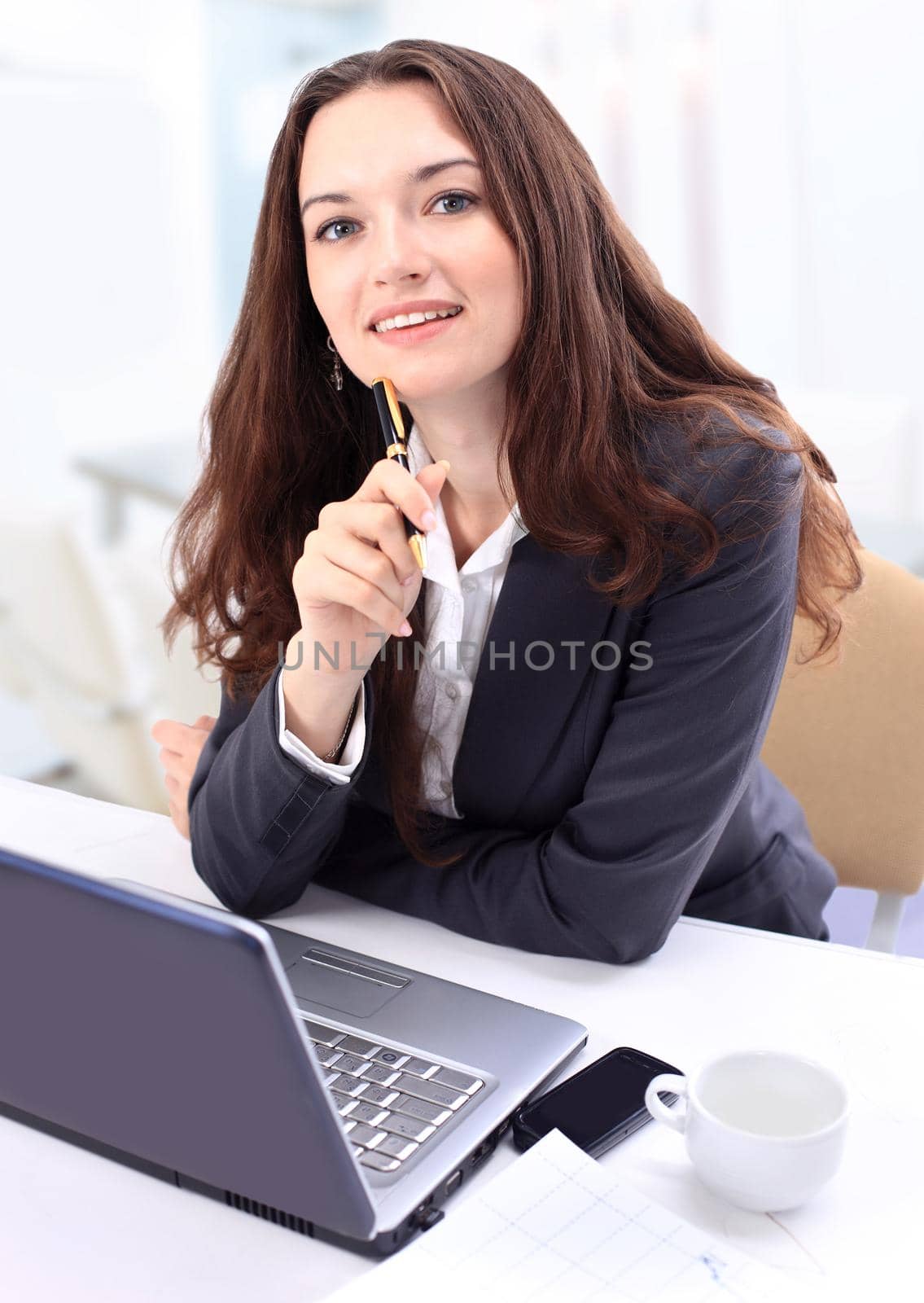 Thoughtful business woman in an office smiling.