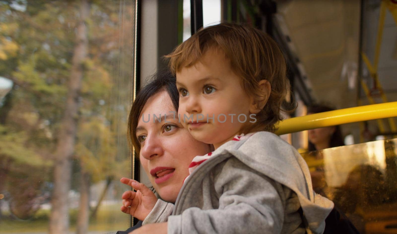 Mother and daughter in a bus. Cheerful small girl and her mom