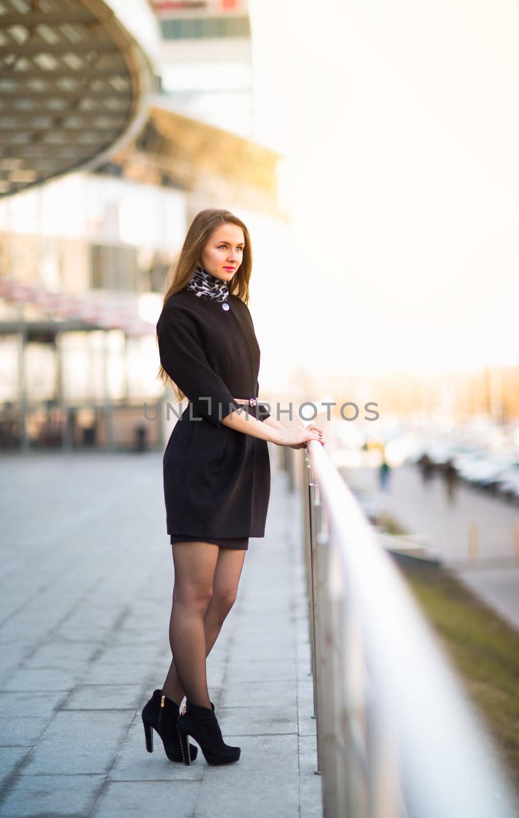 Young business woman standing in the big city and purposefully looking away.