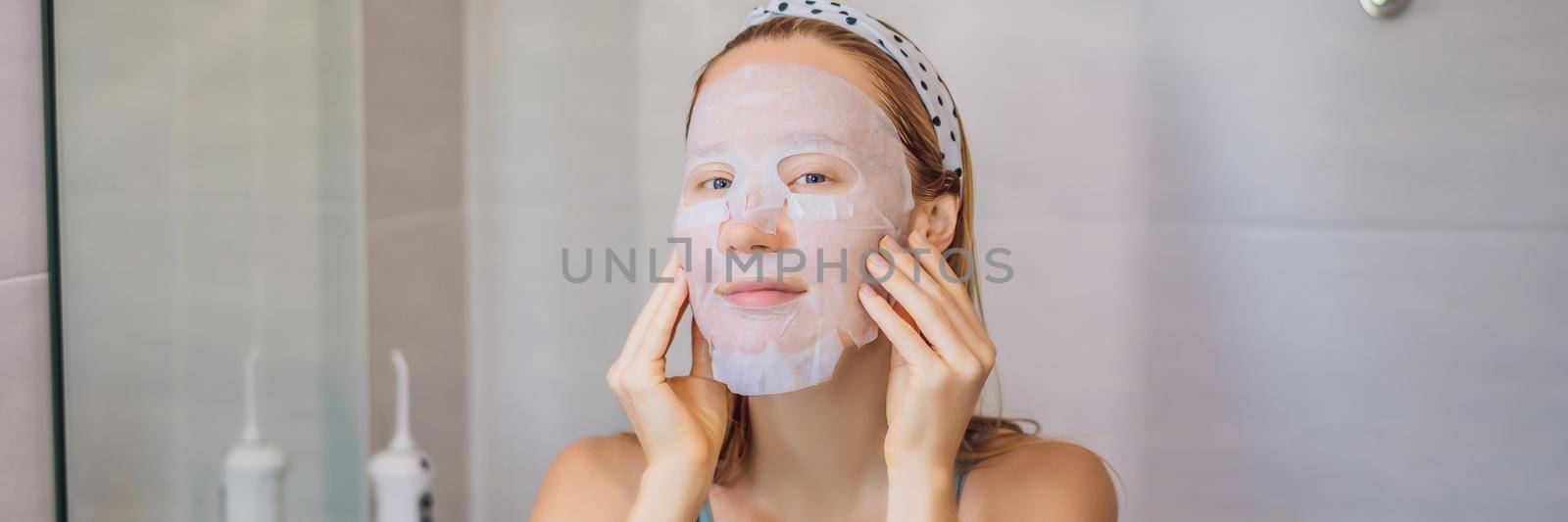 Young red-haired woman doing facial mask sheet. Beauty and Skin Care Concept. BANNER, LONG FORMAT