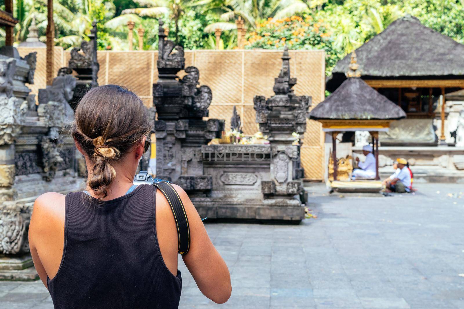 Unrecognizable tourist woman taking photos at Tirta Empul temple in Bali, Indonesia