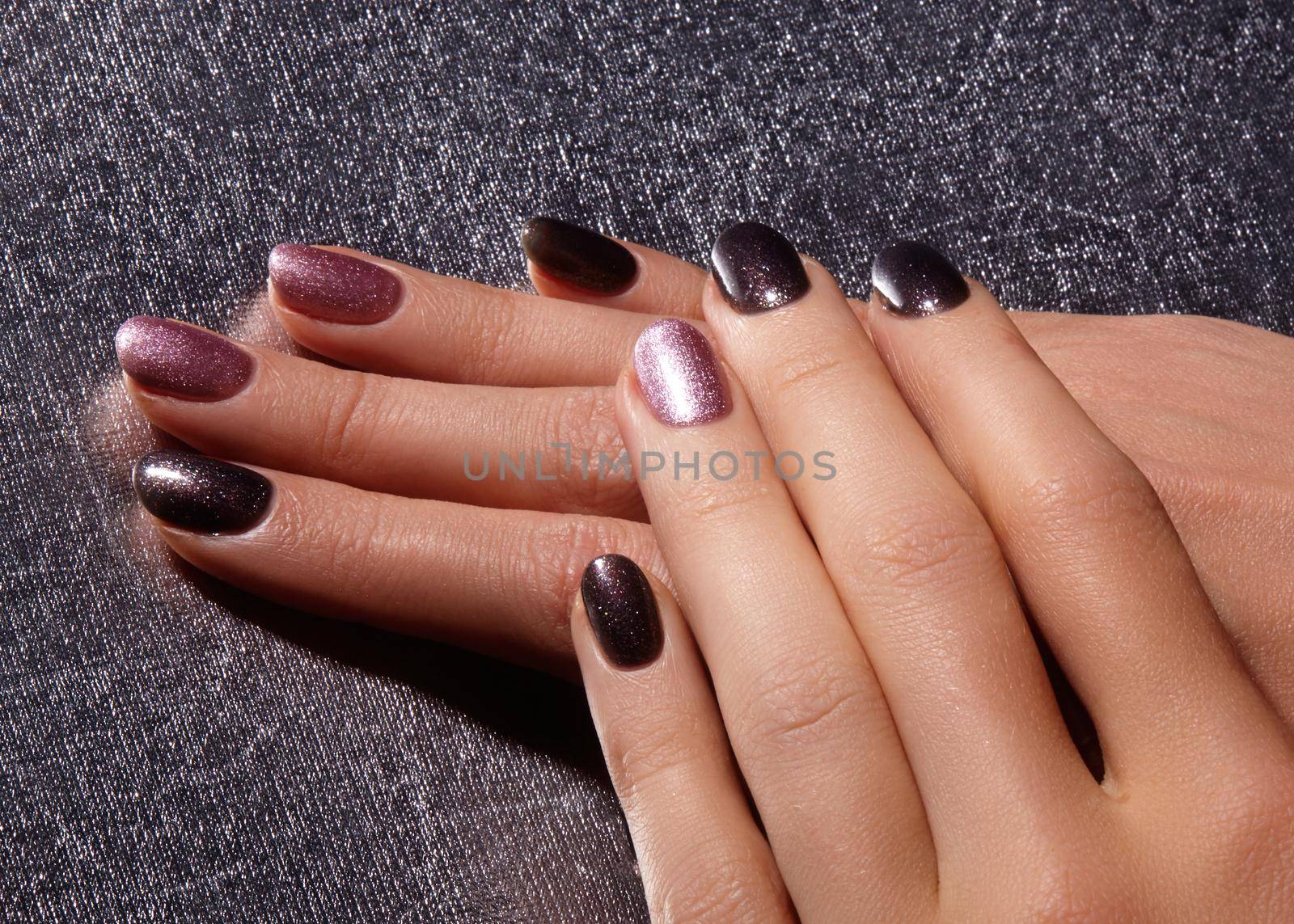 Bright pink and black nail polish wit sparkles. Manicured nails with shiny nail polish. Manicure with gel nailpolish. Fashion art manicure with shiny acrylic lacquer
