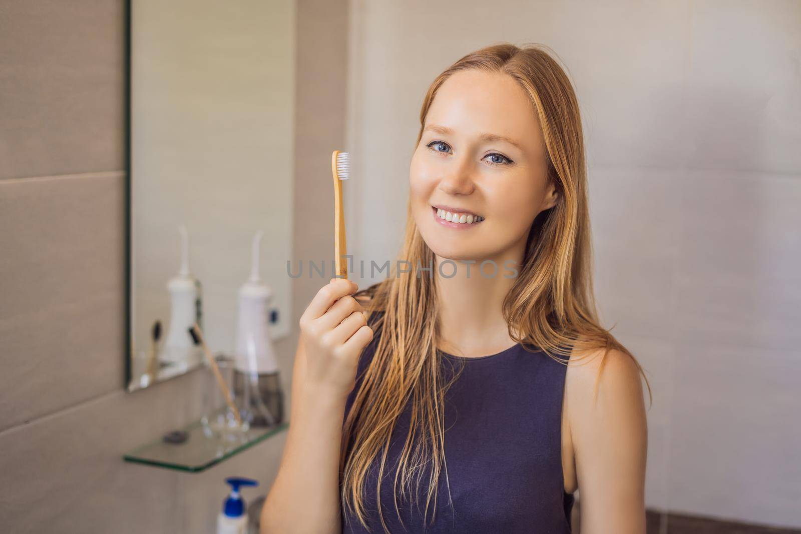 Young and caucasian woman brushing her teeth with a bamboo toothbrush.