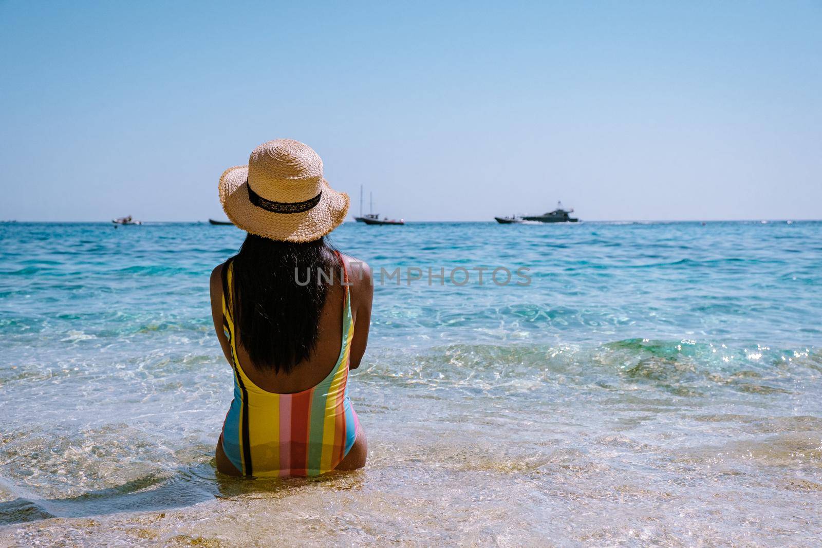 Golfo di Orosei Sardina, Asian women on the beach Sardinia Italy, a young girl on vacation Sardinia Italy, woman playing in the ocean with crystal clear blue water,