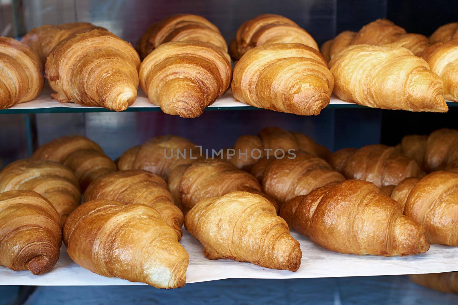 Many fresh croissants on the store shelf