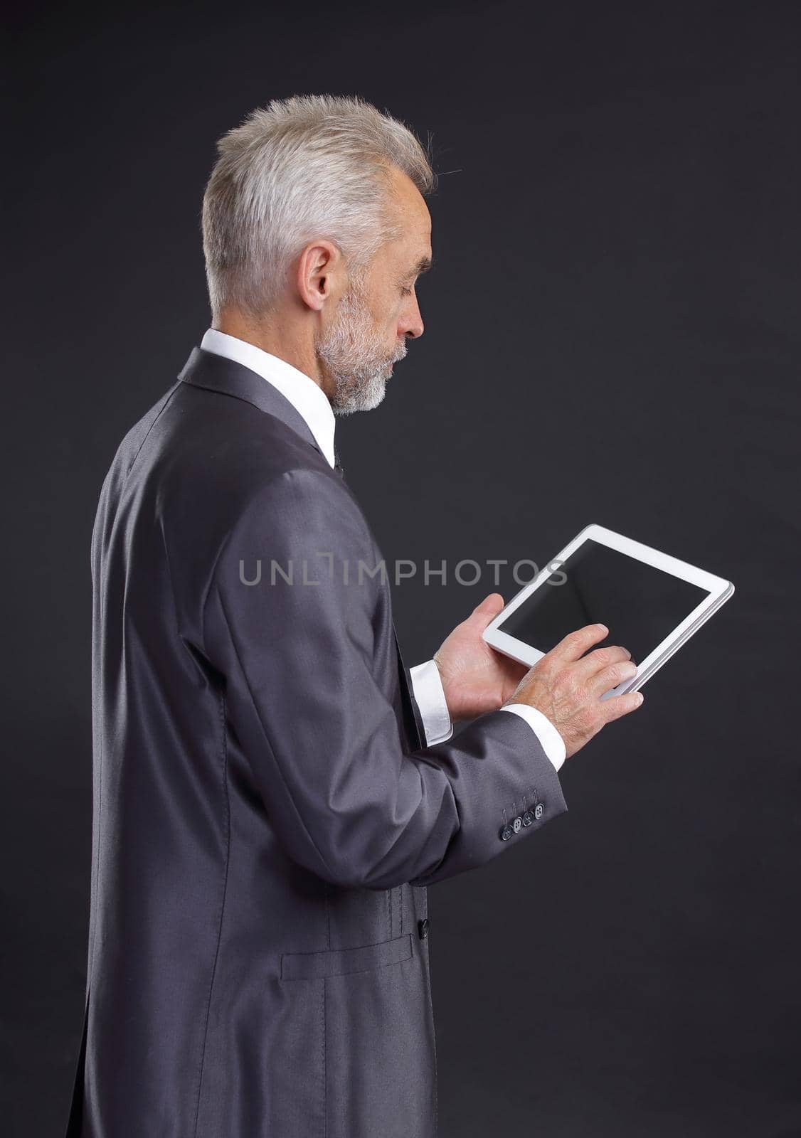 serious businessman looking at digital tablet screen.